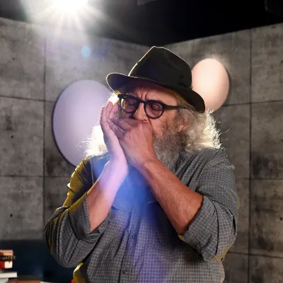 Yves Lambert jouant de l’harmonica sur le plateau de tournage